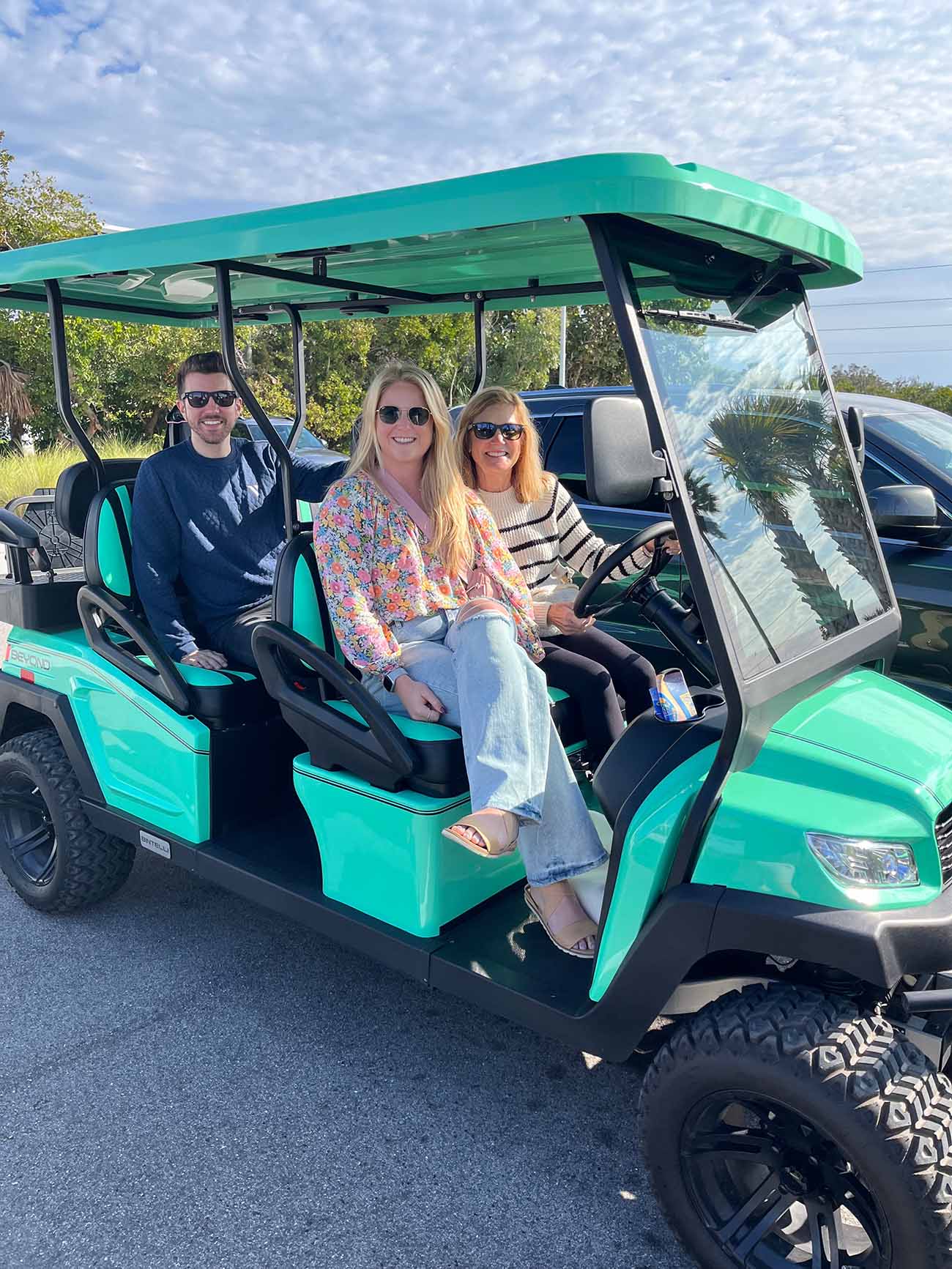 Family on mint green 6-seater golf cart in Osprey, FL